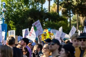 Crowd holding signs at a protest or rally.